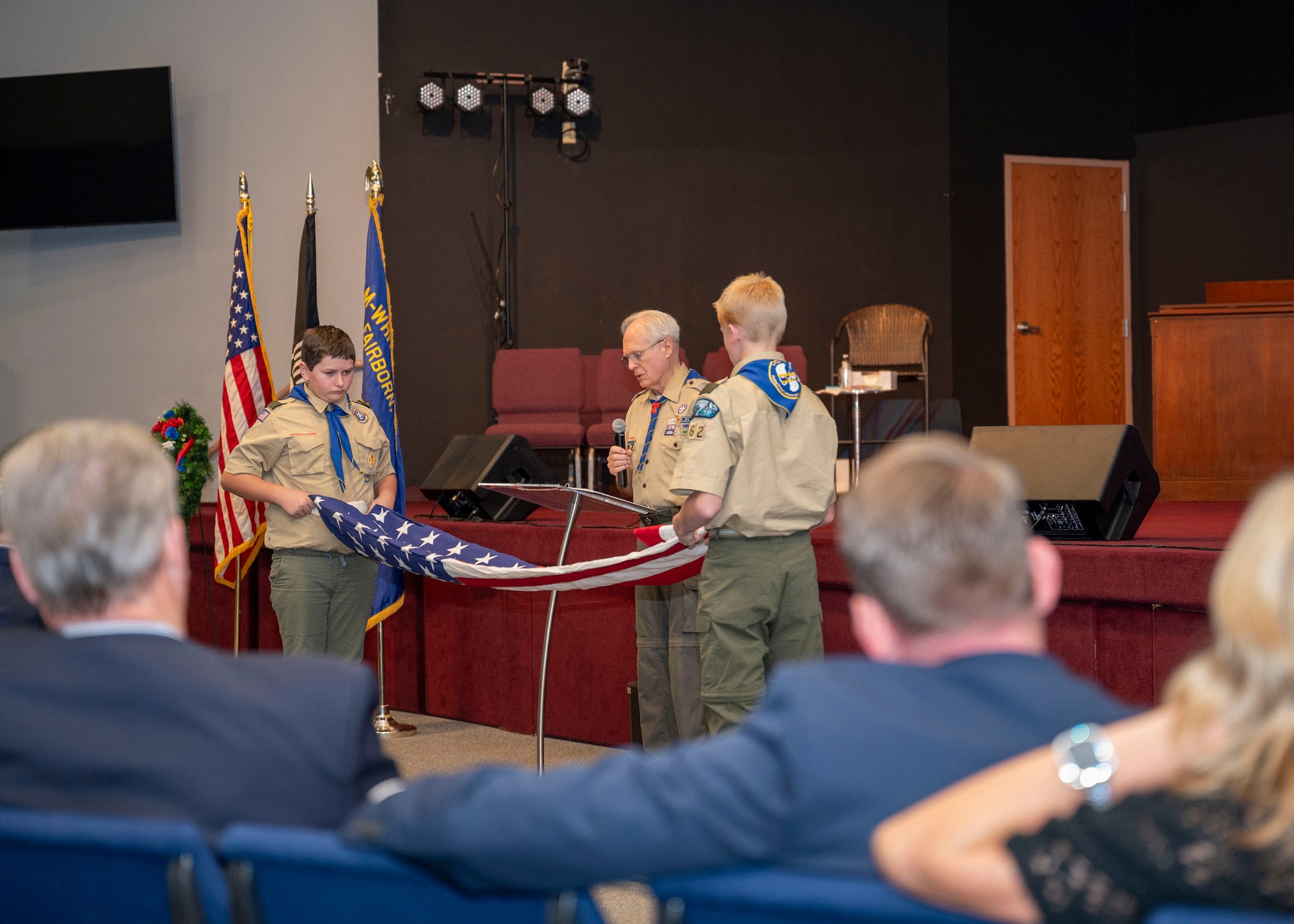 Boy Scout troop 162 performs a 13-fold procedure on an American flag during a Veterans Day ceremony at the United Methodist Church in Fairborn, Ohio, Nov. 11, 2023. Each of the 13 folds holds a special significance. The flag is folded 13 times into a triangle so that only the blue field with stars are visible. (U.S. Air Force photo by Staff Sgt. Mikaley Kline)
