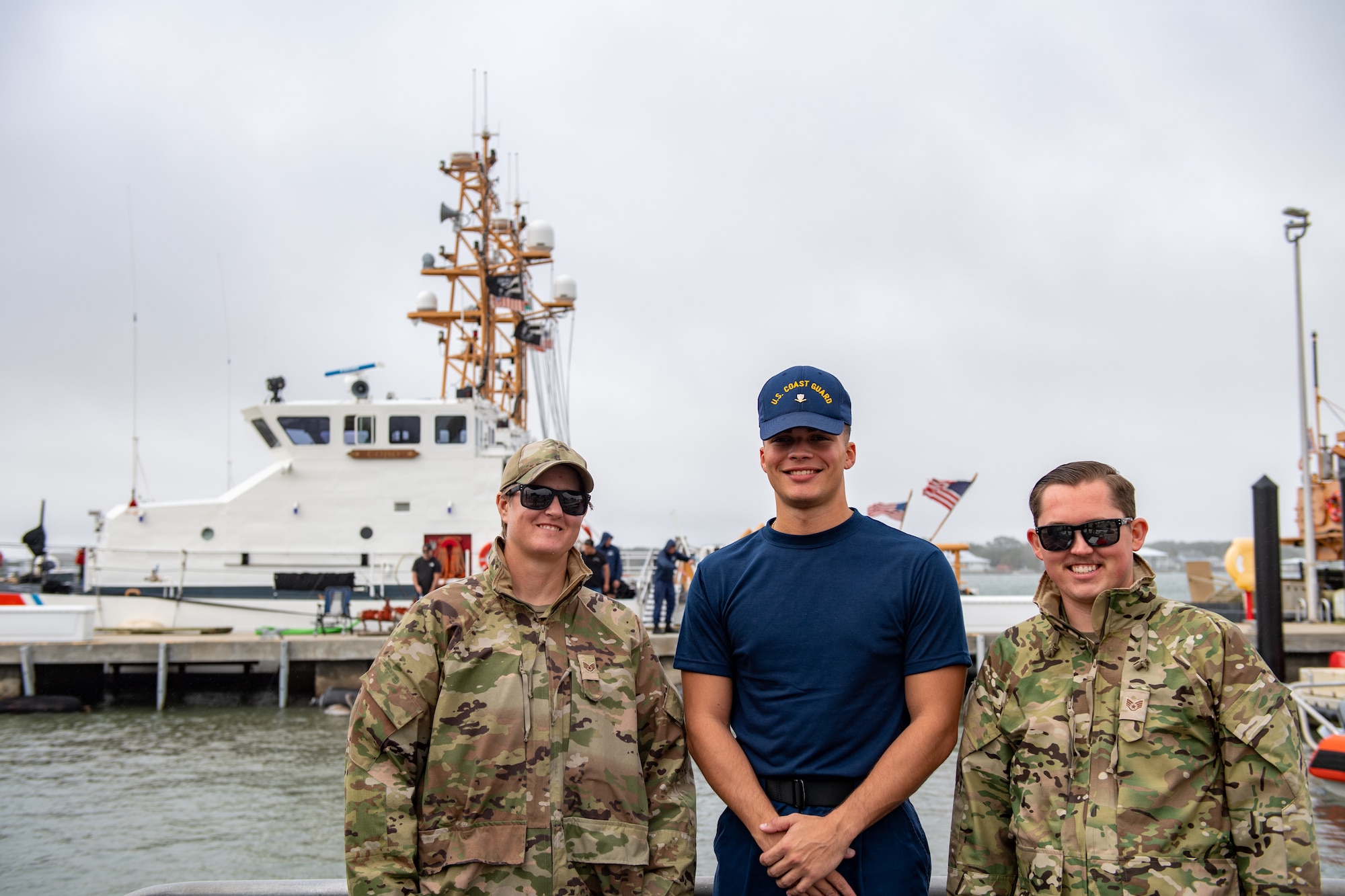 U.S. Air Force Airmen assigned to the 347th Operations Support Squadron smile with a U.S. Coast Guardsman assigned to the Coast Guard Station Mayport during a joint team exercise off the coast of Jacksonville on Nov. 17, 2023. Airmen worked alongside Coast Guardsmen to practice seamless integration for maritime rescue. (U.S. Air Force photo by Senior Airman Courtney Sebastianelli)