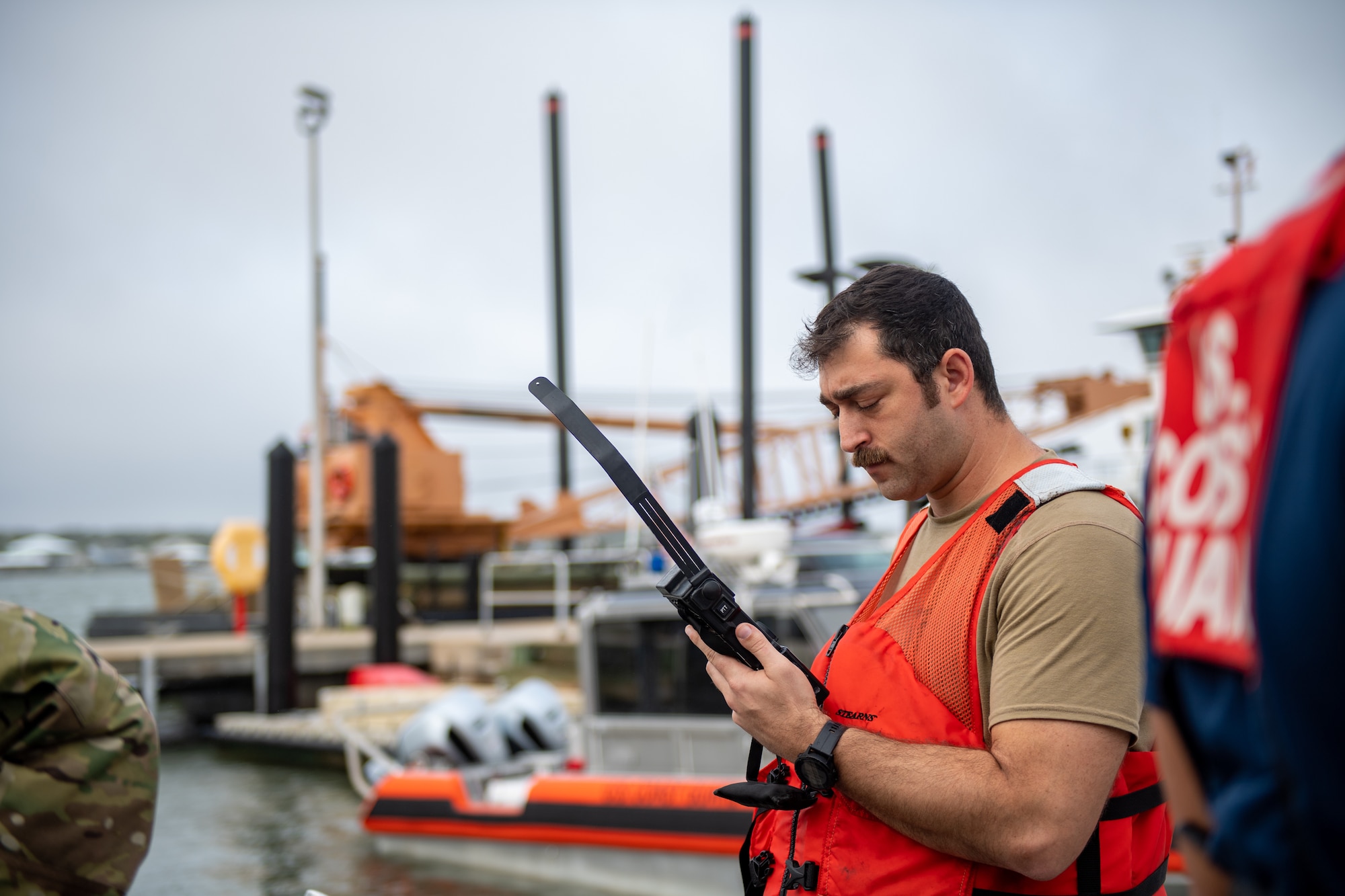 U.S. Air Force Tech. Sgt. Michael Mendes, 347th Operations Support Squadron group weapons and tactics load master, listens to a radio during a simulated joint team exercise with the U.S. Coast Guard station Mayport in Jacksonville on Nov. 17, 2023. The Joint training exercise was part of Mosaic Tiger 24- 1, which was designed to highlight the ability to generate airpower at dispersed locations while combating degraded communications. (U.S. Air Force photo by Senior Airman Courtney Sebastianelli)