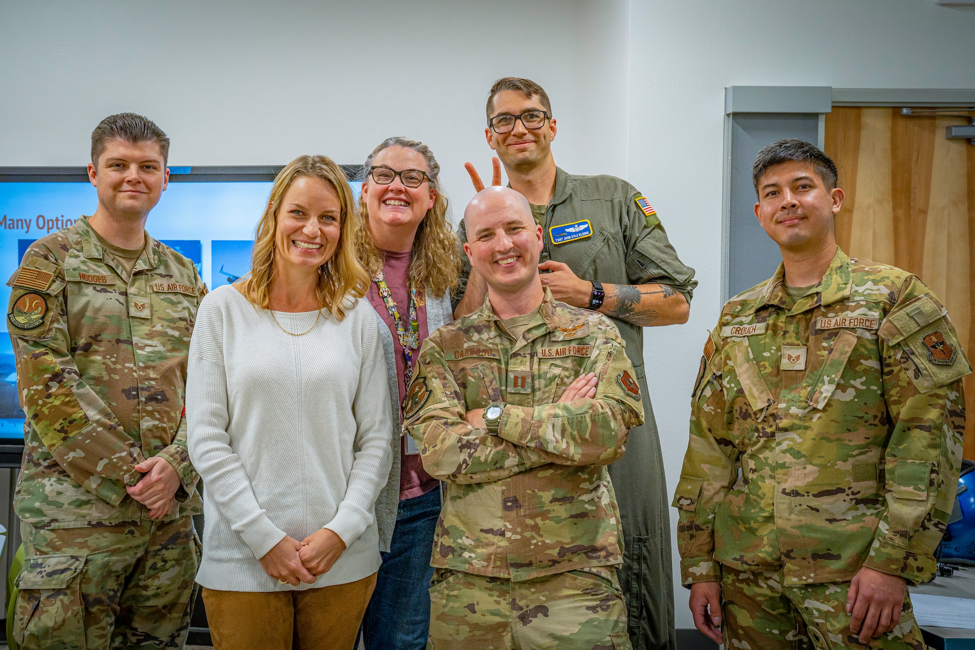 School staff and military service members pose for a group photo.