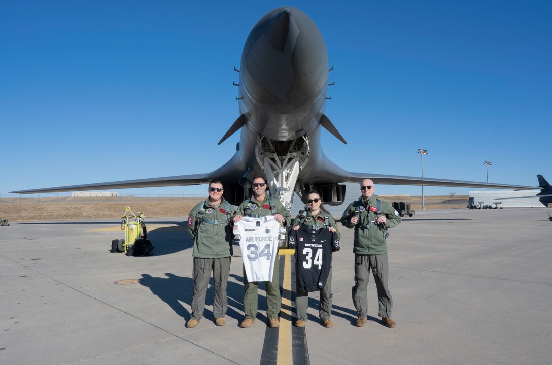 Aircrew assigned to the 34th Bomb Squadron pose with coordinating football jerseys in front of a B-1B Lancer at Ellsworth Air Force Base, South Dakota.