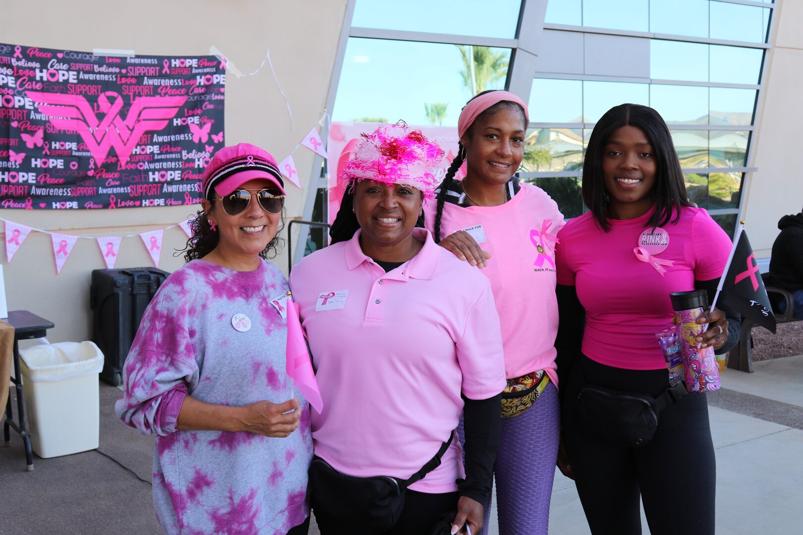 Four women wearing pink standing for a picture in front of a hospital.