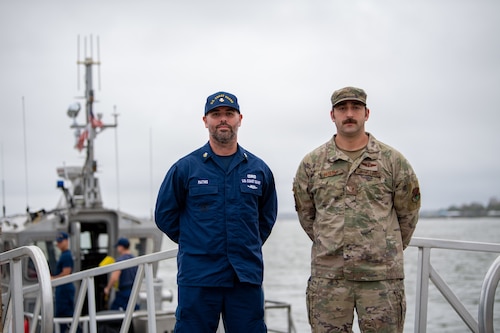 U.S. Coast Guard Petty Officer 1st Class Tim Mathis, USCG STA Mayport unit supervisor, and U.S. Air Force Tech. Sgt.  Michael Mendes, 347th Operations Support Squadron group weapons and tactics load master, pose for a photo during a joint team exercise in Jacksonville on Nov. 17, 2023. According to the Air Force guide titled The Joint Team, or the Purple Book, joint integration requires effective coordination among the military branches. (U.S. Air Force photo by Senior Airman Courtney Sebastianelli)