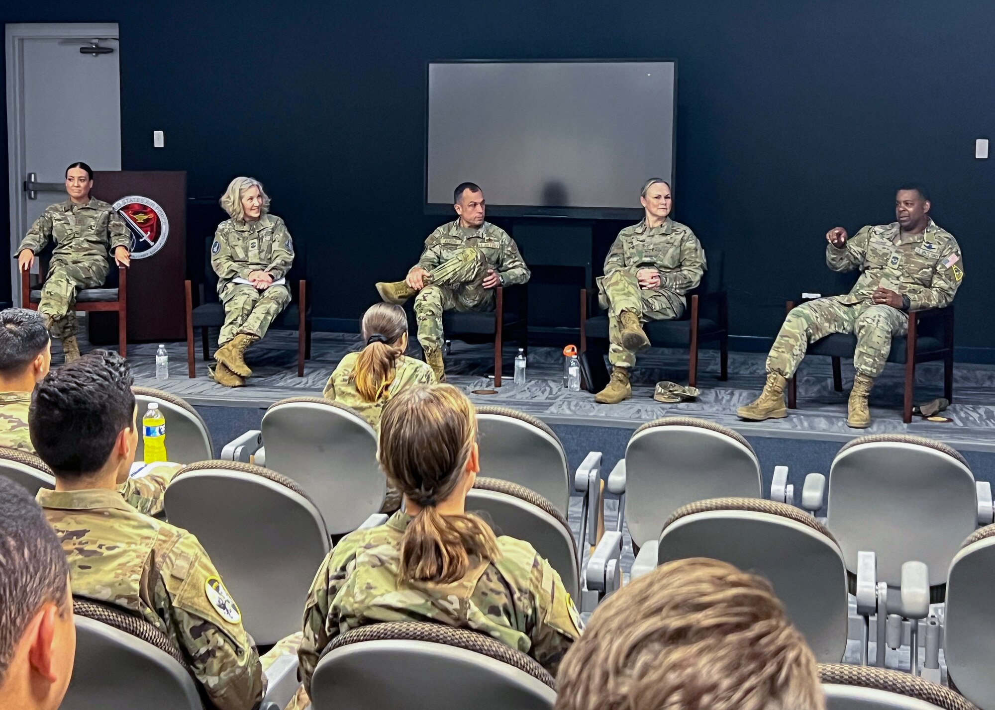 A group of people in uniform speak to an audience.