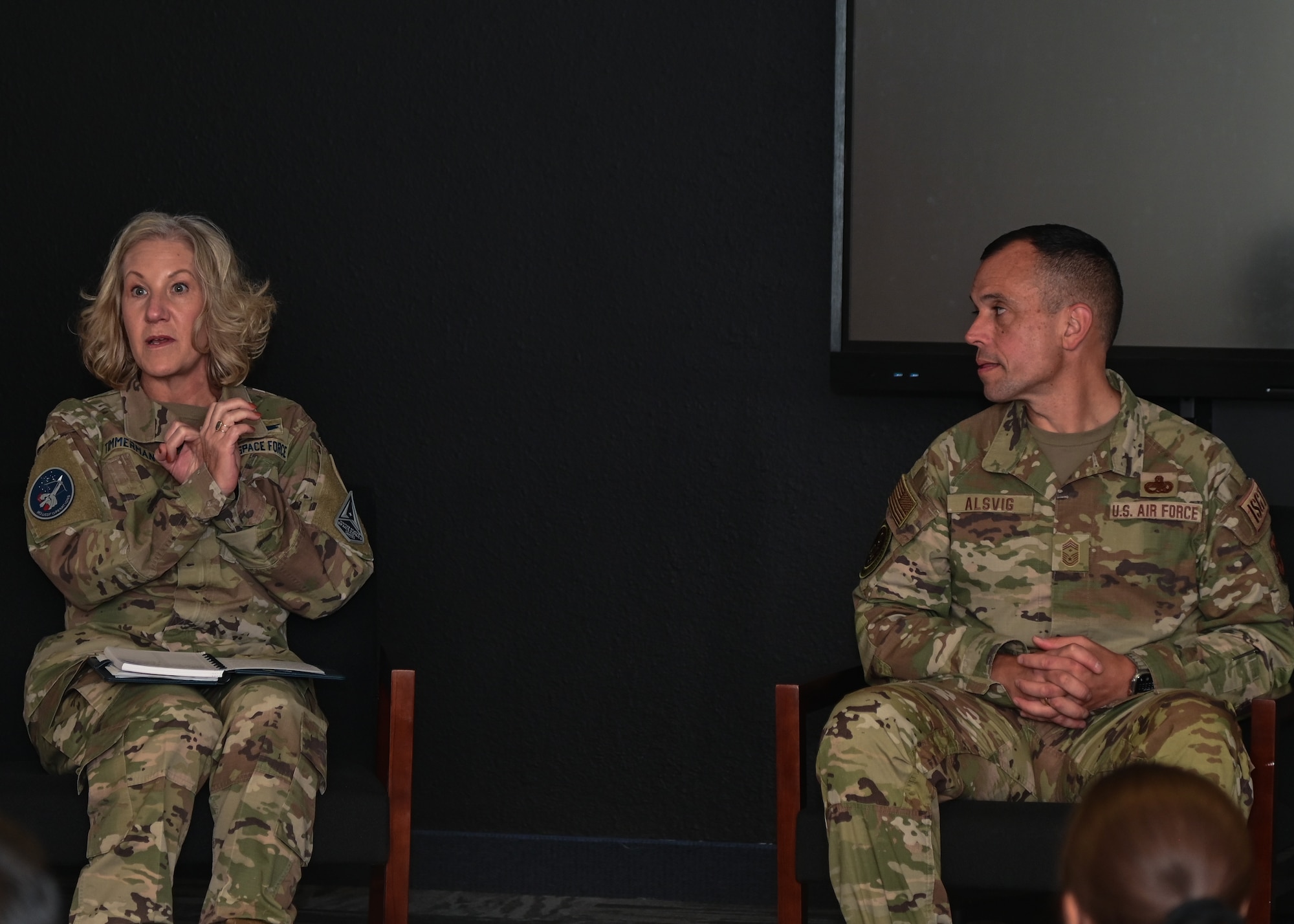 A woman in uniform speaks to a group of people.