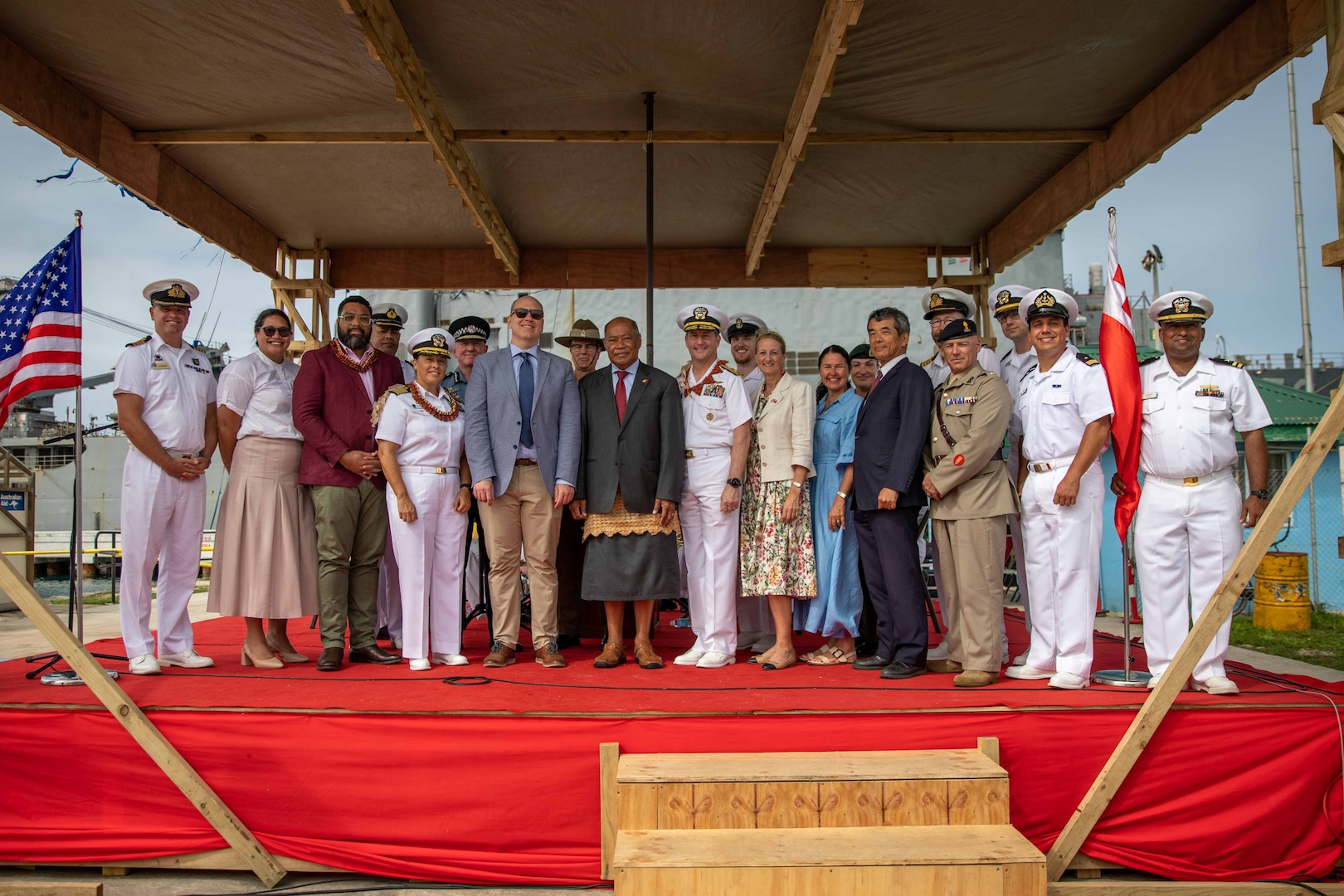 NUKU’ALOFA, Tonga (Nov. 20, 2023) – Representatives of the Royal Navy, Royal Australian Navy, Royal New Zealand Navy, Royal Canadian Navy, Chilean Armed Forces, government of Tonga and the U.S. Navy pose for a group photo after the Pacific Partnership 2023 Tonga closing ceremony in front of Harpers Ferry-class dock landing ship USS Pearl Harbor (LSD 52) , Nov. 20.  Now in its 18th year, Pacific Partnership is the largest annual multinational humanitarian assistance and disaster relief preparedness mission conducted in the Indo-Pacific. (U.S. Navy photo by Mass Communication Specialist 2nd Class Megan Alexander)