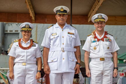 NUKU’ALOFA, Tonga (Nov. 20, 2023) – Capt. Claudine Caluori (left), mission commander of Pacific Partnership 2023, Rear Adm. Mark A. Melson (right), Commander of the Logistics Group Western Pacific, and Capt. Sione Ulakai (center), the Deputy Chief of Defense of His Majesty’s Armed Forces, pose for a group photo during the Pacific Partnership 2023 Tonga closing ceremony in front of Harpers Ferry-class dock landing ship USS Pearl Harbor (LSD 52), Nov. 20.  Now in its 18th year, Pacific Partnership is the largest annual multinational humanitarian assistance and disaster relief preparedness mission conducted in the Indo-Pacific. (U.S. Navy photo by Mass Communication Specialist 2nd Class Megan Alexander)