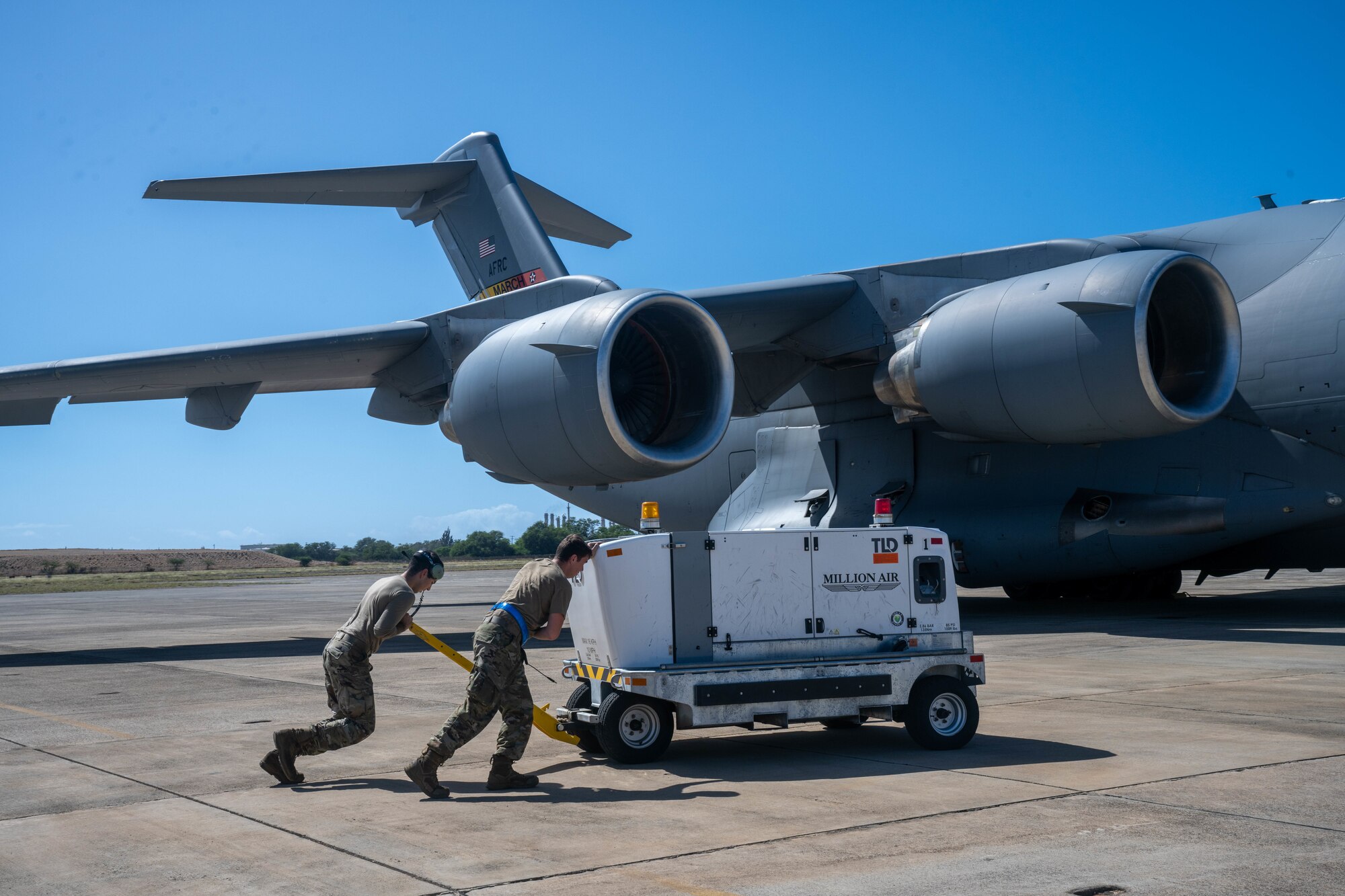 Airman 1st Class Issac Lopez and Senior Airman Jacob Zamora, 15th Aircraft Maintenance Squadron aerospace propulsion journeymen, hook up the auxiliary power unit to a C-17 Globemaster III during Joint Pacific Multinational Readiness Center exercise at John Rodger’s Airfield, Nov. 9, 2023.  Realistic training exercises with our allies and partners, like JPMRC 24-01, strengthen defense relationships, foster multinational interoperability, generate readiness and combat-credible fighting formations. (U.S. Air Force photo by Senior Airman Makensie Cooper)