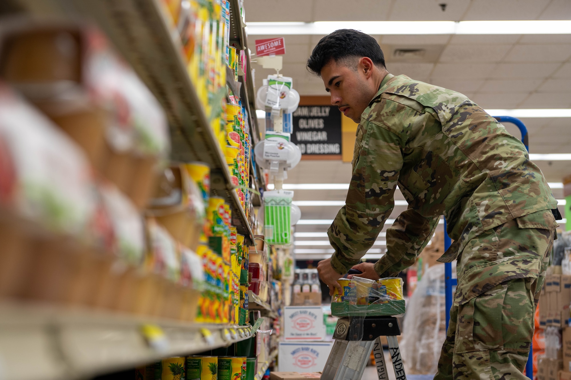 U.S. Air Force Airman 1st Class Andrew Madrid, 36th Communication Squadron cable and antenna systems apprentice, helps stock the shelves in the commissary at Andersen Air Force Base, Guam, Nov. 18, 2023.