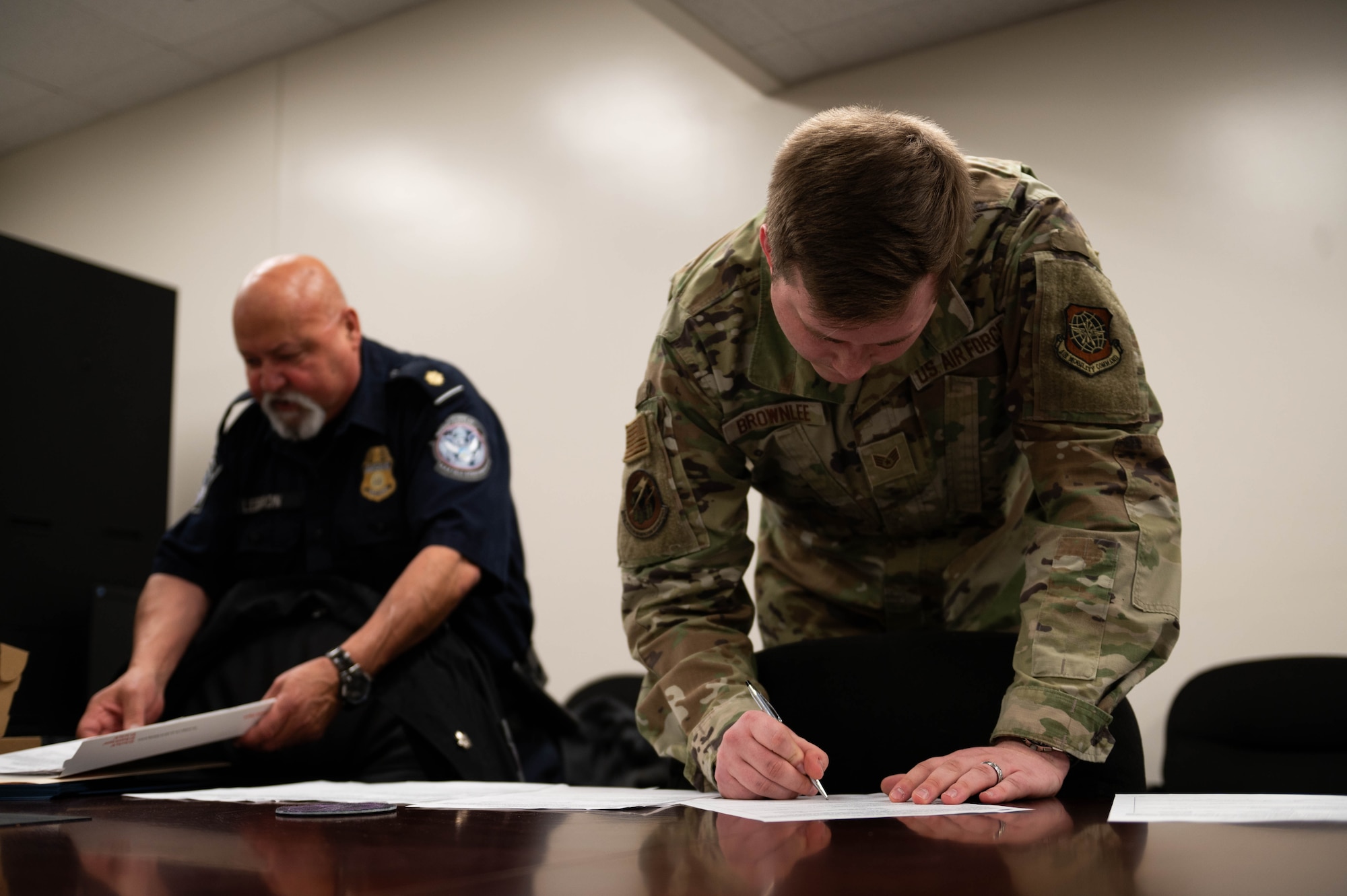 U.S. Air Force Staff Sgt. Graham Brownlee, right, 436th Aircraft Maintenance Squadron mission operations center controller, signs documents during a Military Customs Officer–Excepted program at Dover Air Force Base, Delaware, Nov. 7, 2023. The Military Customs Officer–Excepted (MCO-E) program training entails eight hours of classroom and hands-on on-the-job training, that allows the military customs officers to clear arriving active U.S. military crew and their cargo. (U.S. Air Force photo by Tech. Sgt. J.D. Strong II)