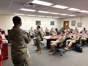Airmen sit in a conference room.