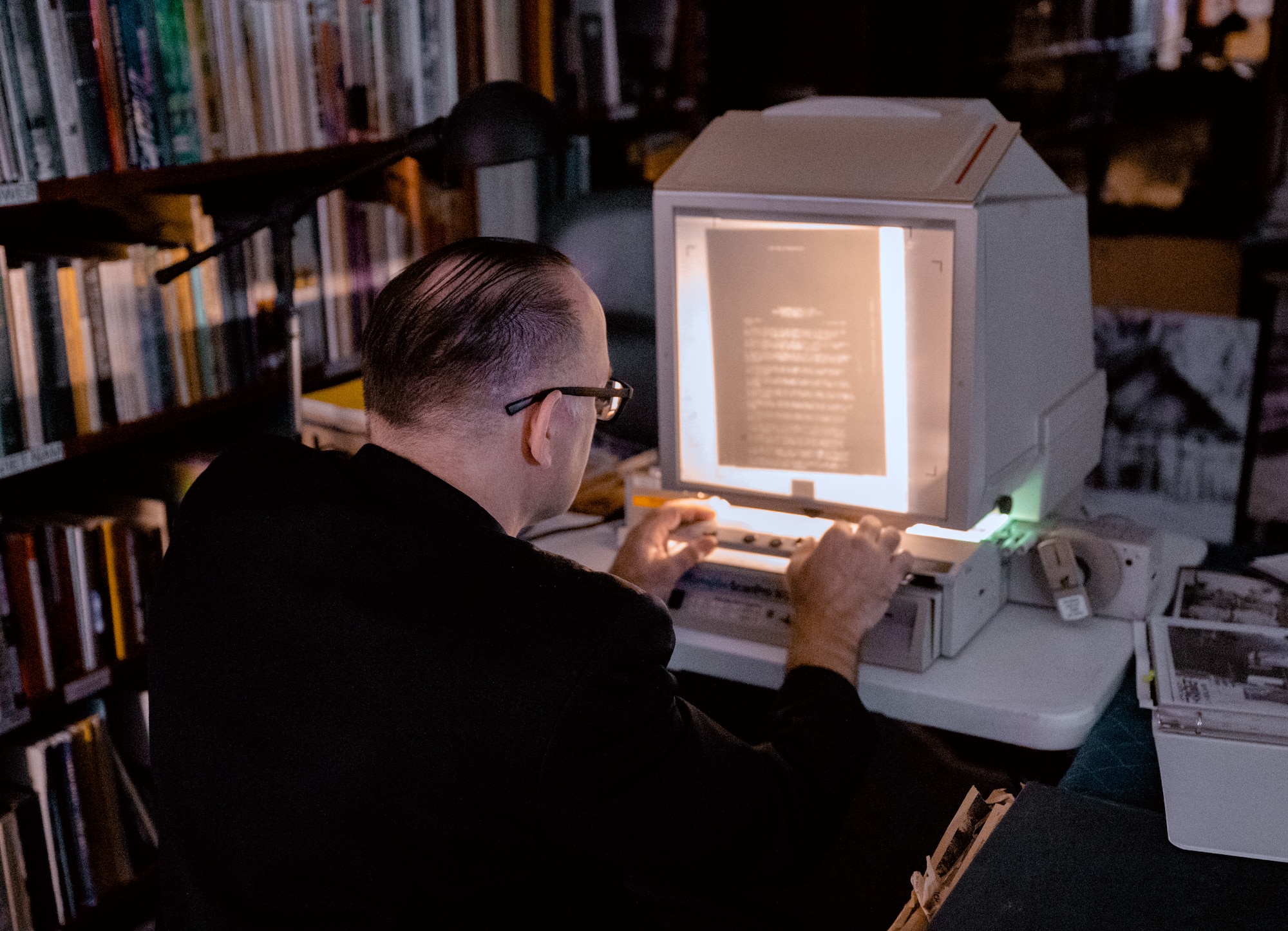 Robert Clark looks at documents on a microfilmer.