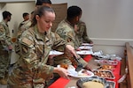 Senior Airman Virginia Barrack, 66th Comptroller Squadron financial management technician, prepares a plate of food during a Thanksgiving-themed Open House at Hanscom Air Force Base, Massachusetts, Nov. 16, 2023. Defense Logistics Agency Troop Support supplies America's armed forces with over $19 billion annually of food, uniforms, protective equipment, medicine, medical supplies, construction and equipment. (U.S. Air Force photo by Todd Maki)