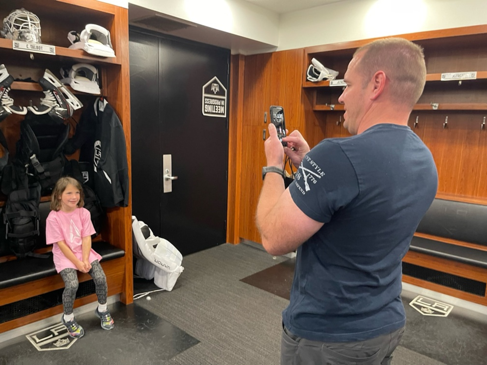 On Nov. 10, Space Systems Command Guardian Lt. Col. Douglas Downs takes a snapshot of his daughter in the Los Angeles Kings’ locker room during a tour of their training facility. In recognition of Veterans Day, the Kings honored Airmen and Guardian from Space System Command and Space Base Delta 3 with a private training facility tour and free game day tickets. Photo by Michiko Riley, Space Systems Command.