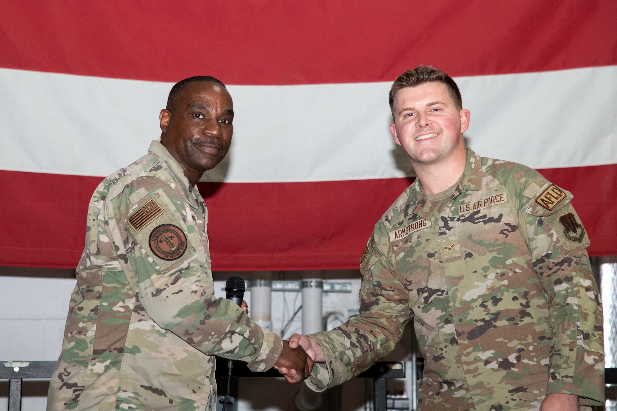 A photo of Chief Master Sgt. Maurice L. Williams coining Airman 1st Class Tyler Armstrong.