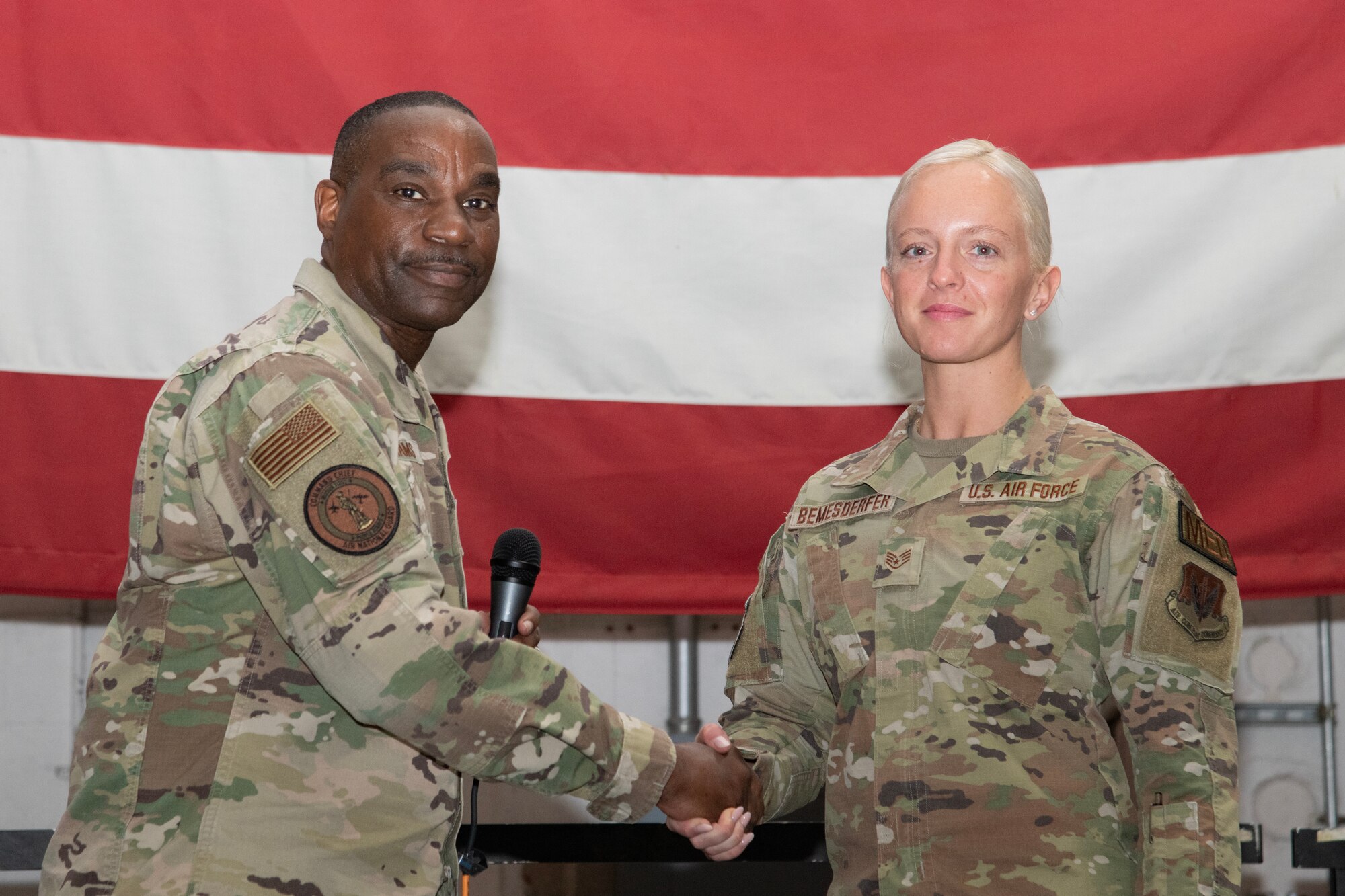 A photo of Chief Master Sgt. Maurice L. Williams coining Staff Sgt. Elizabeth Bemesderfer.