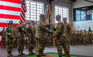 U.S. Army Command Sgt. Maj. John Keenan (left), the incoming 97th Military Police Battalion, 89th Military Police Brigade, III Armored Corps, receives the battalion colors from Lt. Col. Andrew Sergent (right), the battalion commander, during the 97th MP Bn. change of responsibility ceremony at King Field House on Fort Riley, Kansas, November 9, 2023. Keenan assumed responsibility during the ceremony, where the passing of the colors symbolized the bestowment of responsibility over the battalion to him. (U.S. Army photo by Spc. Joshua Holladay)