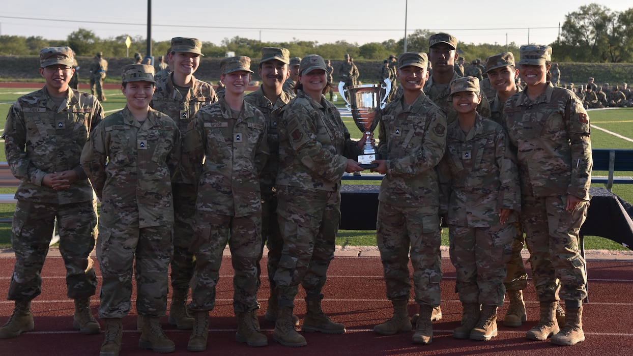 Angelo State University ROTC students pose for a portrait with Col. Angelina Maguinness, 17th Training Wing Commander, and Chief Master Sgt. Khamillia Washington,17th Training Wing Command Chief, during the 17th TRW Drill Down Competition at Mathis Field, Goodfellow Air Force Base, Texas, Nov. 17, 2023. ASU and Goodfellow often hold collaborative events that involve ROTC involvement on and off base to prepare them for the transition from cadet to Air Force leader. (U.S. Air Force photo by Airman James Salellas)