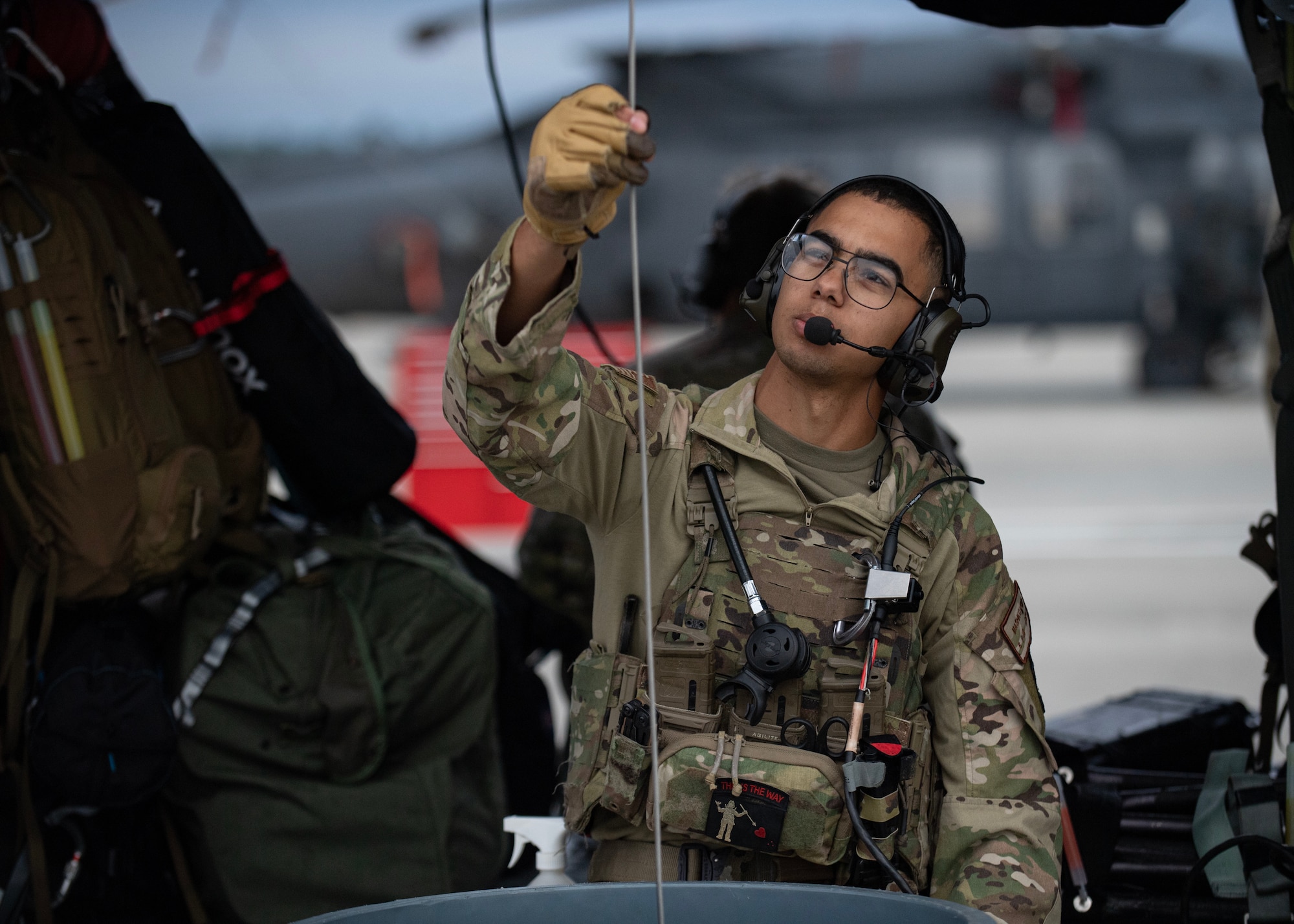 A U.S. Air Force Airman assigned to the 347th Rescue Group inspects a rescue hoist cable prior to launch for participation in exercise Mosaic Tiger 24-1 at Moody Air Force Base, Georgia, Nov. 13, 2023. As a safety precaution, Airmen conduct multiple pre-flight inspections on the HH-60W Jolly Green II beginning their assigned mission. (U.S. Air Force photo by Master Sgt. Daryl Knee)