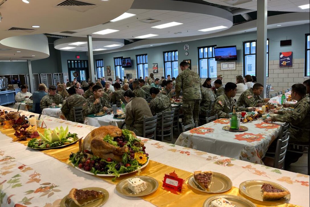 Several plates, plated with Thanksgiving-themed food items, sit on a decorated table.