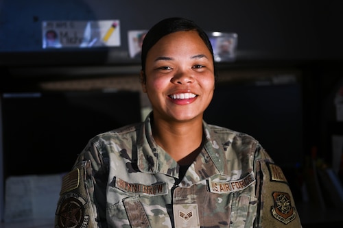 An airman poses for a photo in her office.