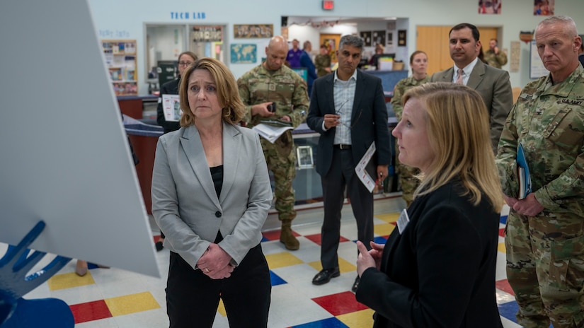 Deputy Defense Secretary Kathleen Hicks looks at a large poster.