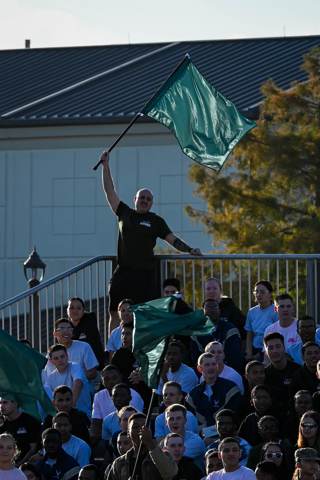 A member of the 334th Training Squadron waves a green flag in support of his drill team at the Fourth Quarter Drill Down competition at the Levitow Training Support Facility drill pad on Keesler Air Force Base, Mississippi, Oct. 27, 2023.