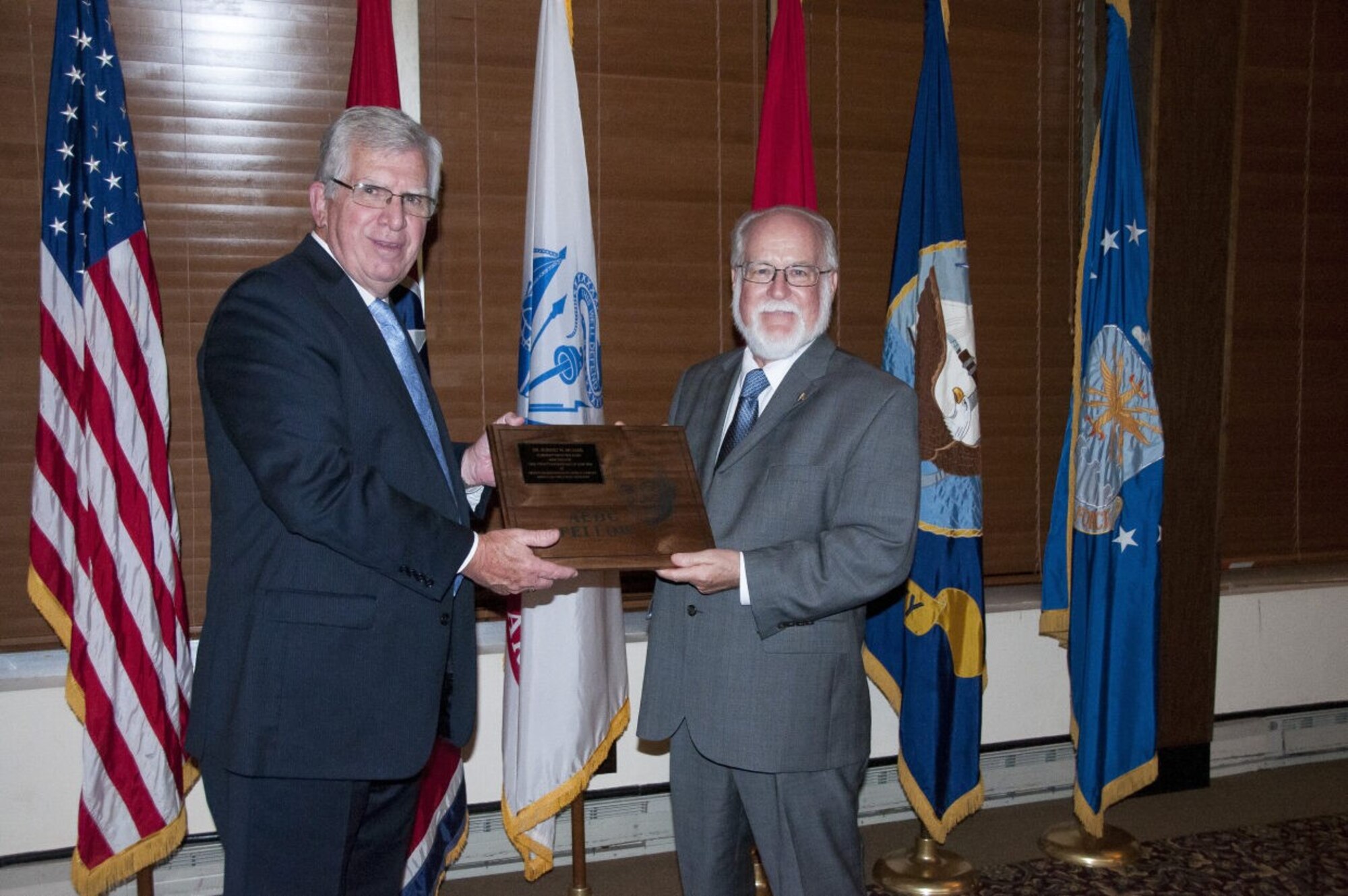 Claude Morse, right, receives the Arnold Engineer Development Complex Lifetime Achievement Fellows plaque from then-AEDC Chief Technologist Dr. Edward Kraft during a June 24, 2016, banquet at the Arnold Lakeside Complex to recognize his induction as an AEDC Fellow. Morse, who worked at Arnold for more than 30 years and is credited for marketing the capabilities of AEDC to the media, national and international industry, and the local community, passed away Nov. 12, 2023, at the age of 79. (U.S. Air Force photo by Holly Peterson)