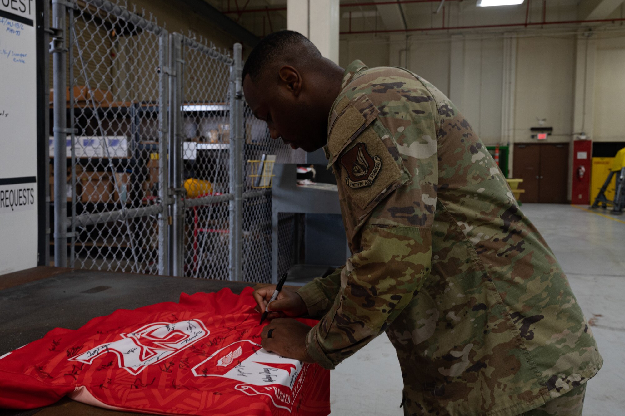 Photo of an Airman signing the official Linebacker of the Week jersey