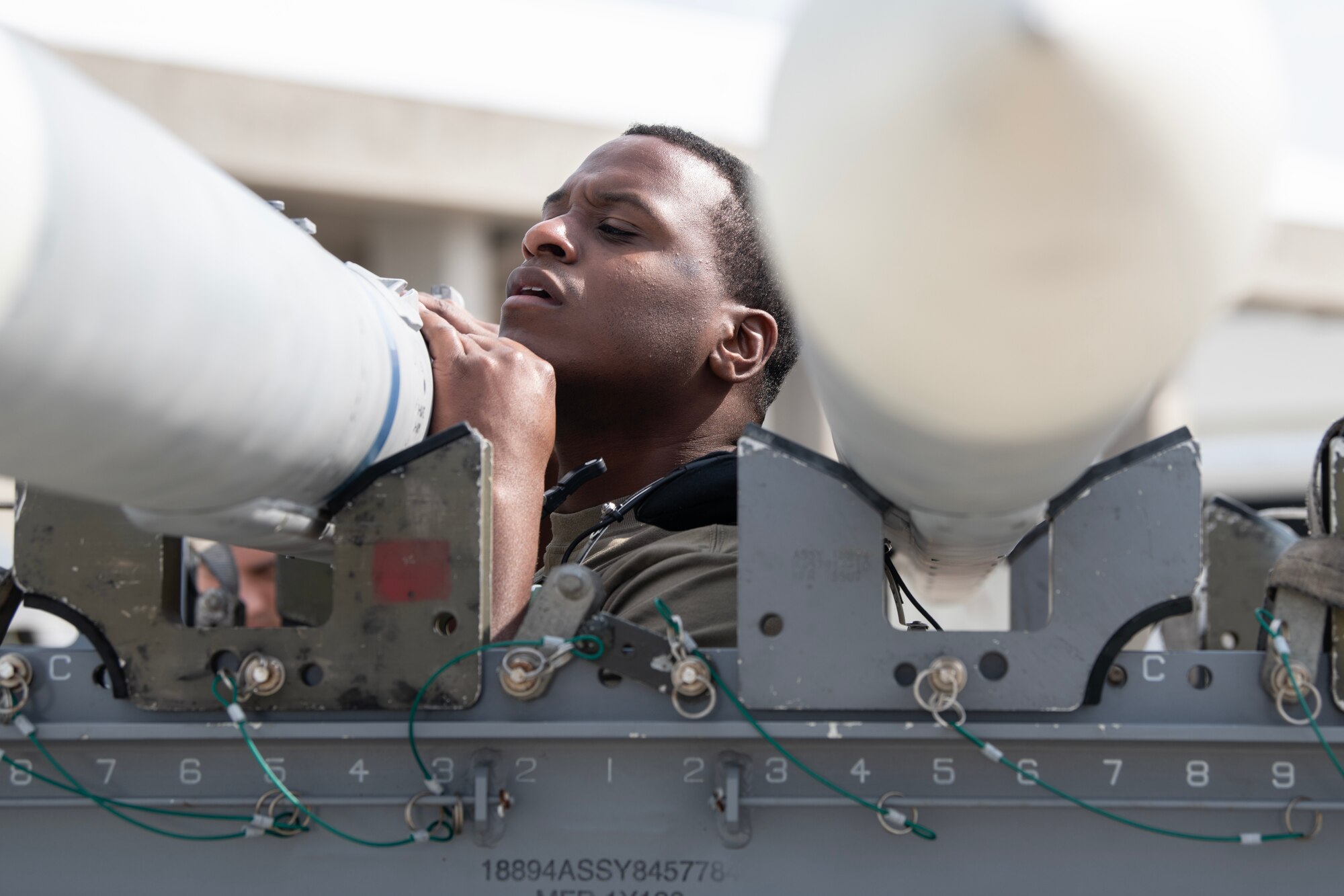 An Airman from the 18th Aircraft Maintenance Squadron prepares an AIM-120 Advanced Medium Range Air-to-Air Missile to be loaded onto an F-15C Eagle during a weapons load competition at Kadena Air Base, Japan, Nov. 17, 2023. Kadena’s aircraft weapons load teams face off quarterly to test the skill and professionalism of Kadena Airmen while building camaraderie among the base’s diverse team of aircraft maintainers. (U.S. Air Force Photo by Staff Sgt. Jessi Roth)