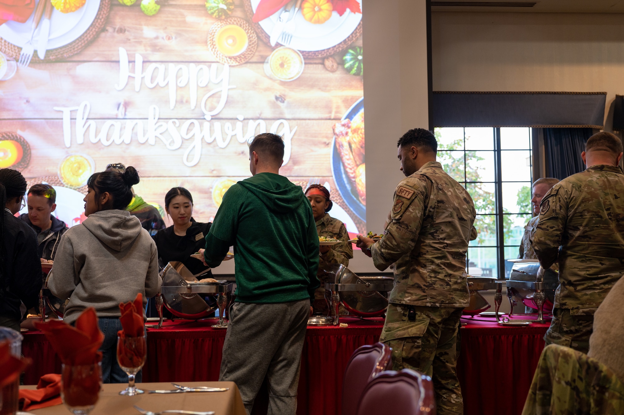 U.S. service members assigned to the 8th Fighter Wing, Kunsan Air Base, Republic of Korea, process through a meal line during the annual Thanksgiving meal.