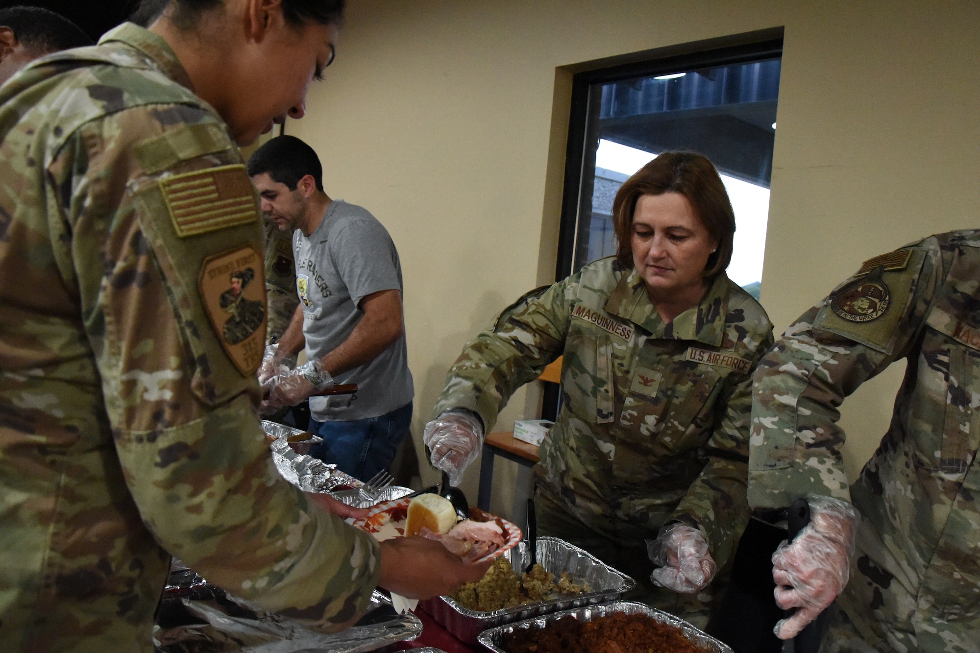 U.S. Air Force Col. Angelina Maguinness, 17th Training Wing commander, serves students a Thanksgiving meal at the Crossroads Thanksgiving event, Goodfellow Air Force Base, Texas, Nov. 17, 2023. Maguinness was one of many leadership members that volunteered to serve students. (U.S. Air Force Photo by Staff Sgt. Nathan Call)
