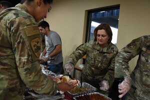 U.S. Air Force Lt. Col. Jose Quintanilla, 17th Logistical Readiness Squadron commander, serves turkey to students at the Crossroads Thanksgiving event, Goodfellow Air Force Base, Texas, Nov. 17, 2023. Service members from every branch of the military were present to receive a Thanksgiving dinner provided by volunteers from the military and surrounding community. (U.S. Air Force Photo by Staff Sgt. Nathan Call)