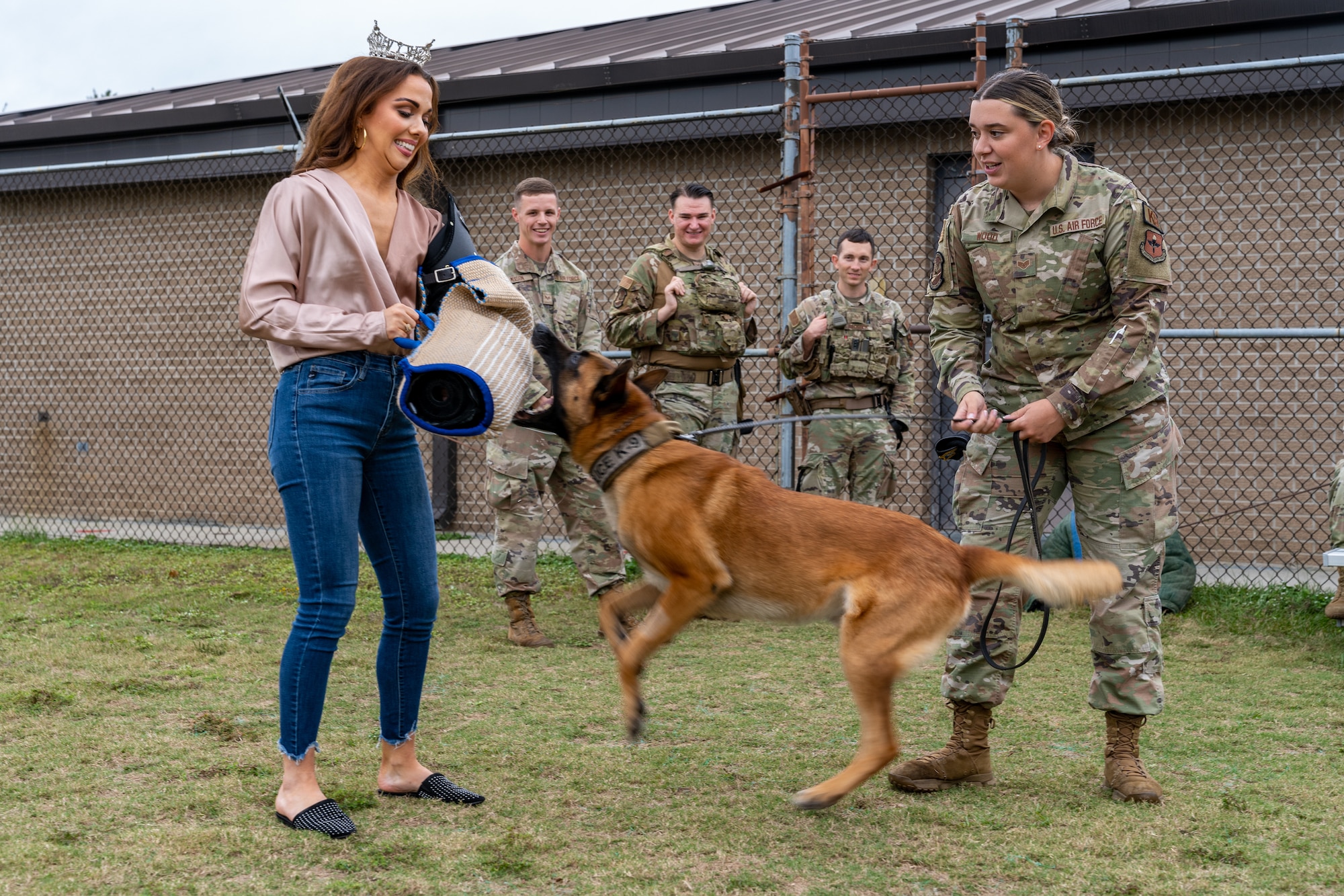 Vivian O’Neal, Miss Mississippi 2023, participates in a military working dog demonstration with U.S. Air Force Staff Sgt. Ryan Wood, 81st Security Forces Squadron kennel master, and Victor, 81st SFS military working dog, during her tour at Keesler Air Force Base, Mississippi, Nov. 20, 2023.