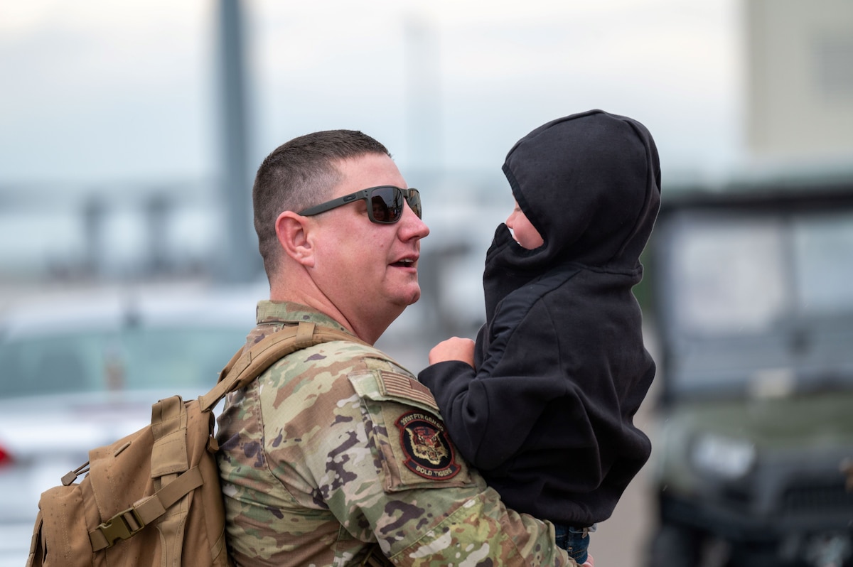 Airman holds his son.