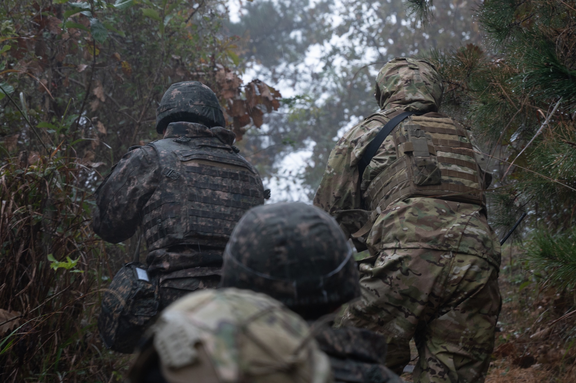 Republic of Korea Air Force 38th Fighter Group military police and U.S. Air Force 8th Security Forces Squadron defenders advance up a hill during an anti-terrorism response exercise.