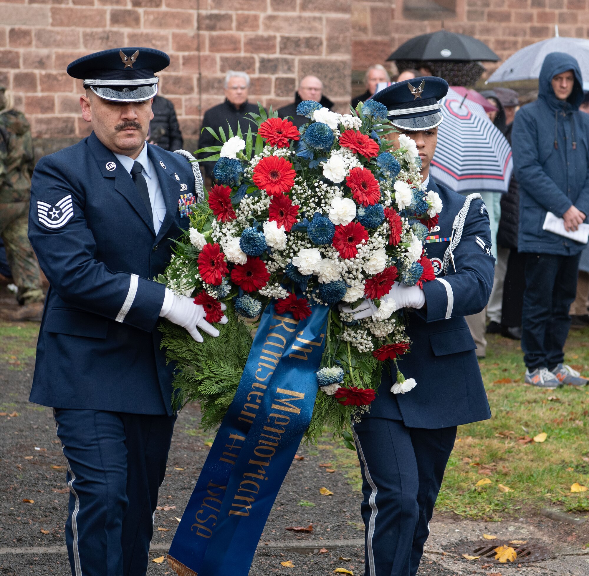 two people carry wreath