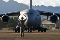 Staff Sgt. Robert Patterson, 621st Contingency Response Squadron aircraft maintainer, marshals in a C-17 Globemaster III during the Joint Pacific Multinational Readiness Capability exercise at Wheeler Army Airfield, Hawaii, Nov. 3, 2023.