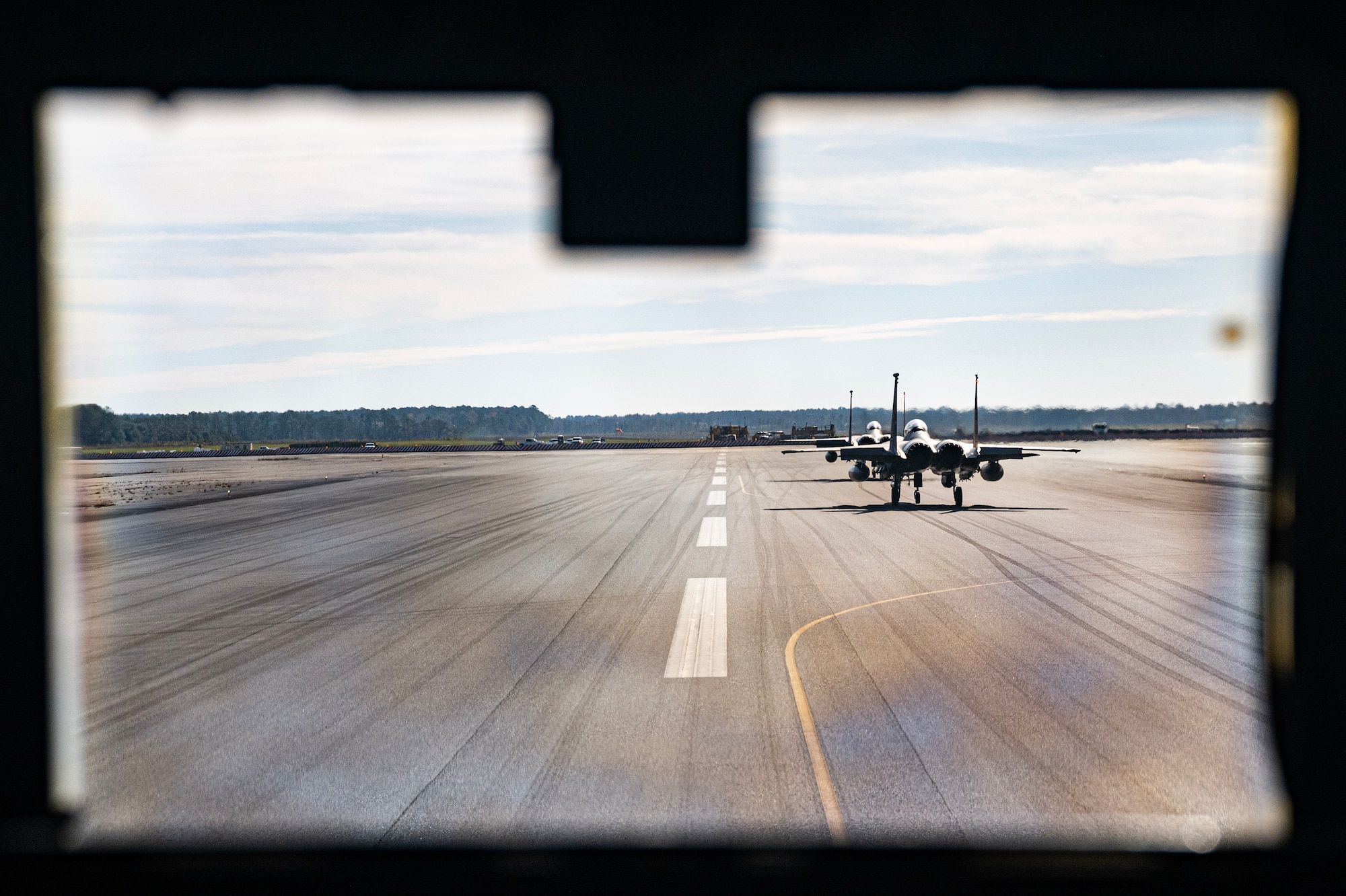 Two U.S. Air Force F-15E Strike Eagles, assigned to the 335th Fighter Squadron, Seymour Johnson Air Force Base, North Carolina, sit on the taxiway in front of a U.S. Air Force C-130J Super Hercules, assigned to the 19th Airlift Wing, Little Rock Air Force Base, Arkansas, at Marine Corps Air Station Cherry Point, North Carolina, Nov. 14, 2023, for Exercise Razor Talon 24-1. RT-24 is an agile combat employment focused exercise, designed to test the 4th Fighter Wing's ability to operate as a lead wing to generate combat airpower while continuing to move, maneuver, sustain the wing and subordinate force elements in a dynamic contested environment. (U.S. Air Force photo by Staff Sgt. Devin M. Rumbaugh)