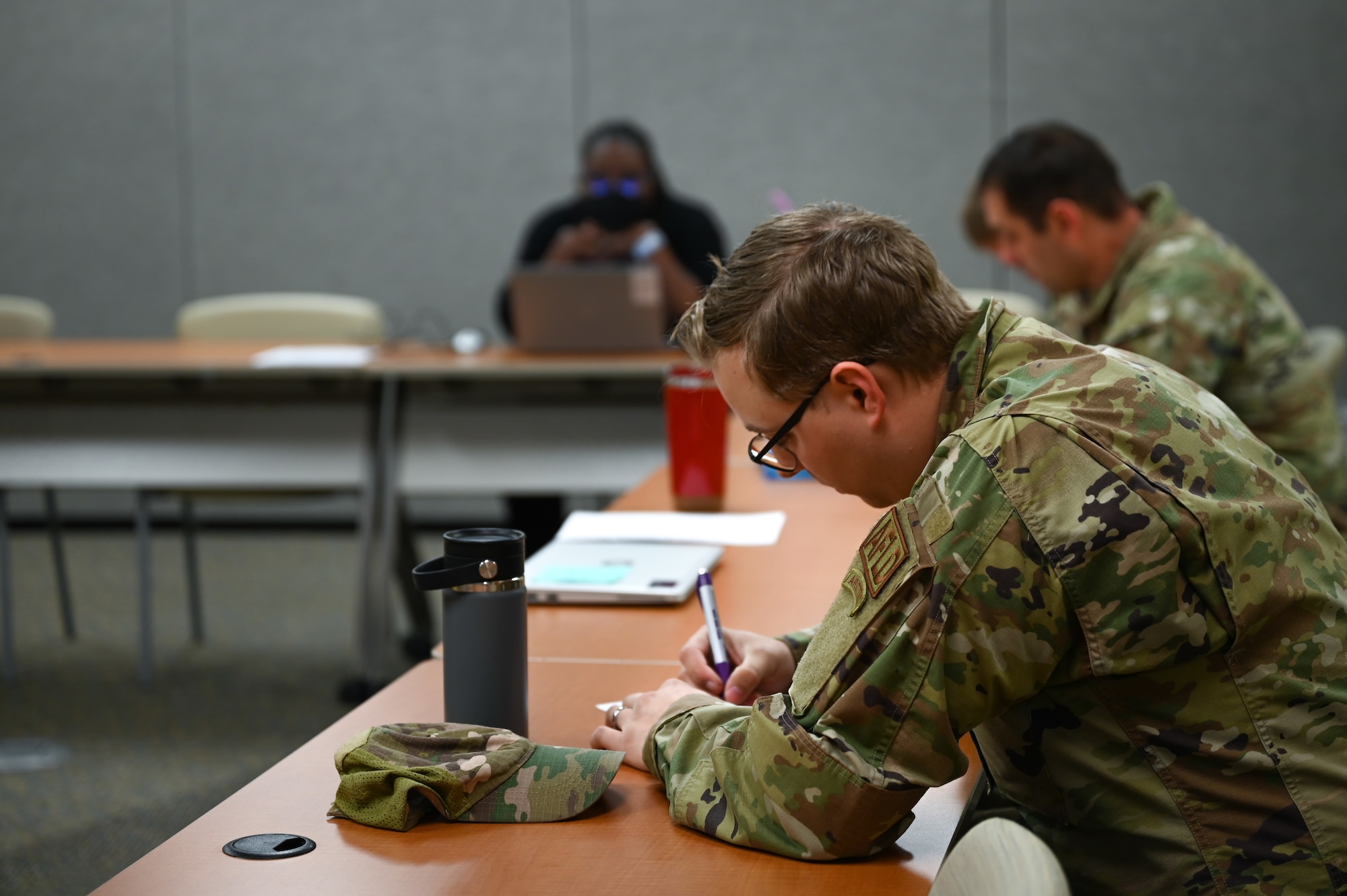 Airmen writing down their information on a piece of paper