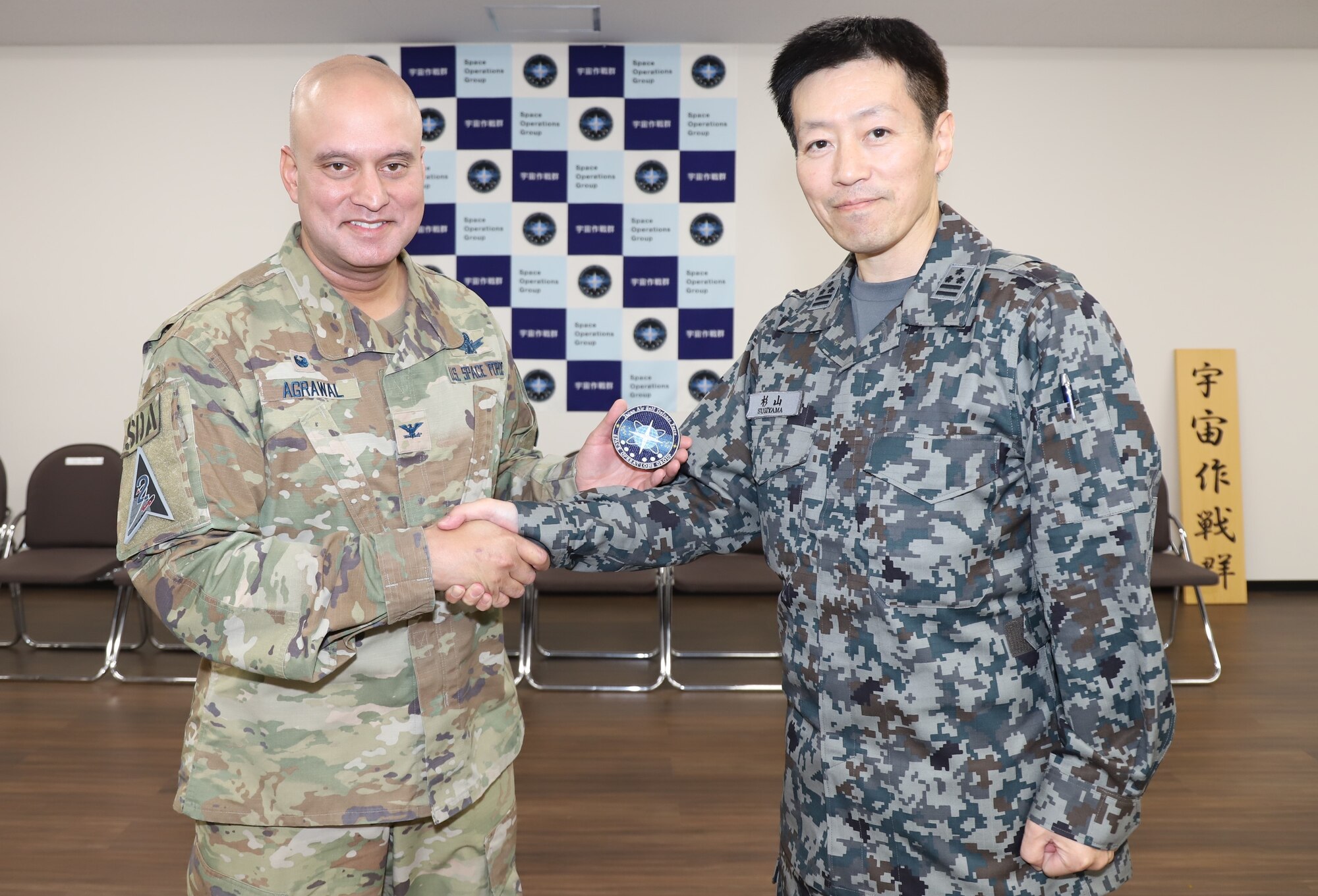 U.S. Space Force Col. Raj Agrawal, commander of Delta 2-Space Domain Awareness and Space Battle Management, left, receives a Space Operations Group patch from Japan Air Self-Defense Force Col. Kimitoshi Sugiyama, commander of the SOG, right, during a visit to Fuchu, Japan, Oct. 5, 2023. The two leaders discussed U.S.-Japan space operations collaboration and identified space situational awareness data and information sharing initiatives. (Courtesy photo)