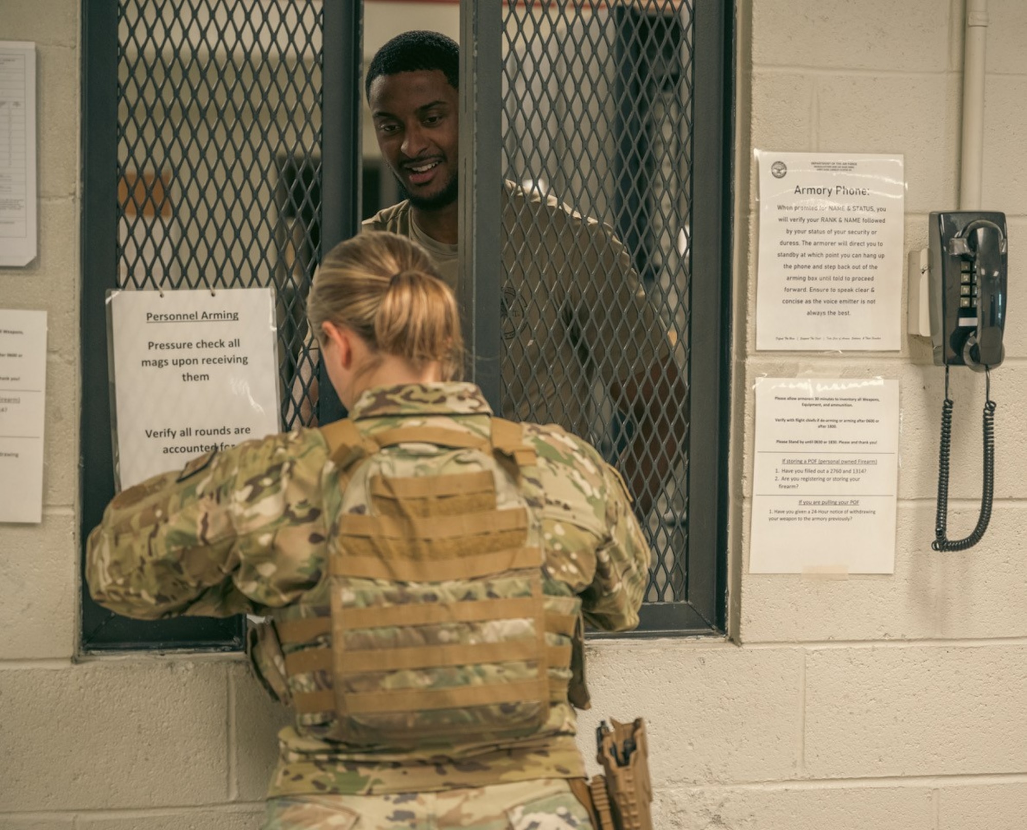 An Airman signs out a weapon to a Defender.