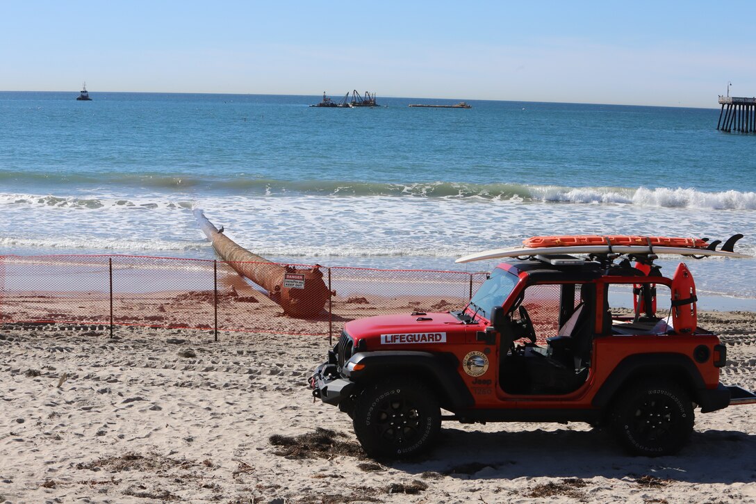 City of San Clemente life guards patrol beach near beach end of pipeline. Manson Construction Company, placed a submerged pipeline for this project that runs parallel to the pier, from the ocean to the shore, where a dredge vessel will connect and pump sand onto the beach.