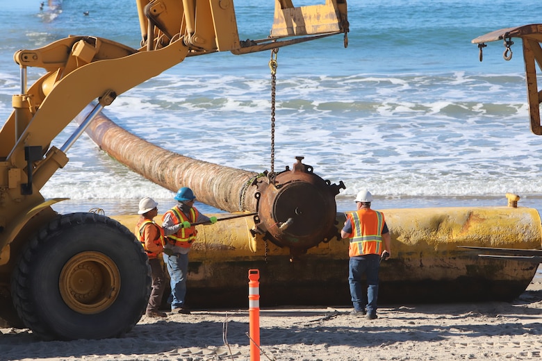 Crews from USACE contractor, Manson Construction, prepare to remove beach end of massive sand pipeline.