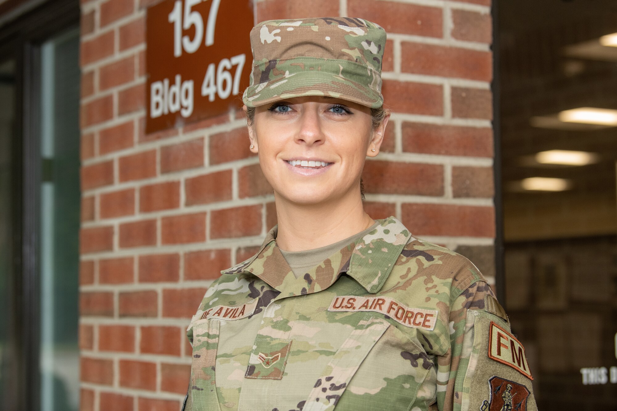 Airman posing for a photo outside building.
