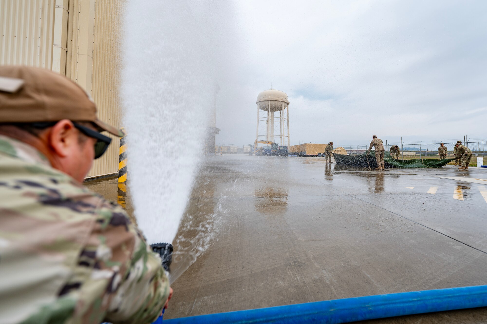 Airman sprays water to simulate a storm during a Prime Base Engineer Emergency Force or “Prime BEEF” training at Kunsan Air Base.