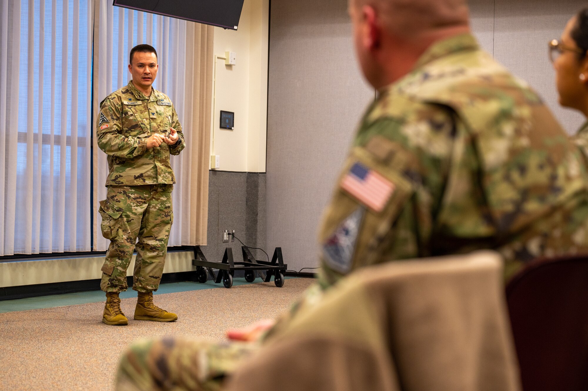 Service member speaks in front of others.