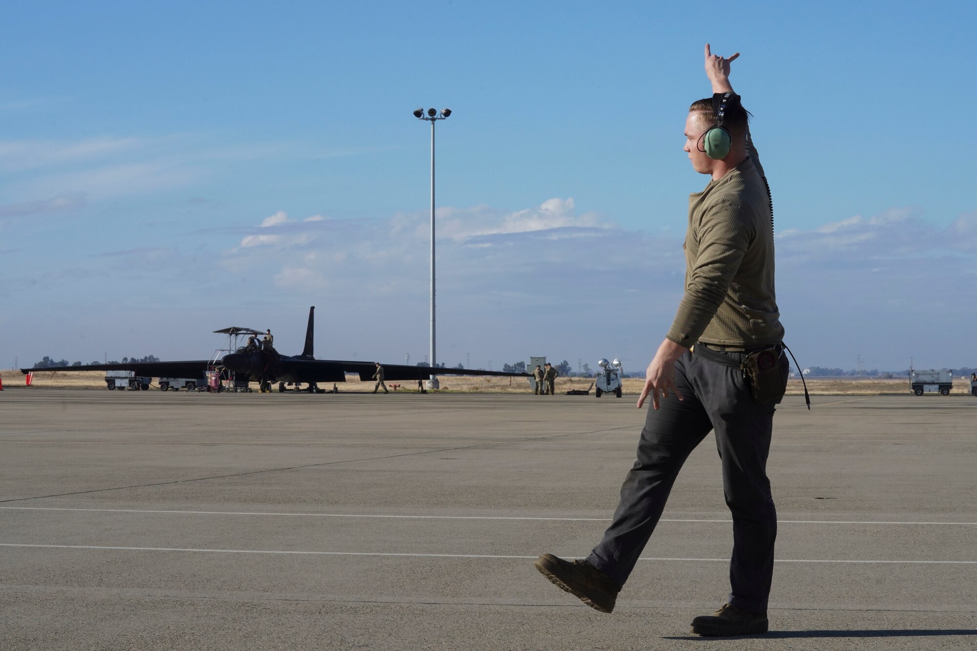 U.S. Air Force Senior Airman Jonathan Davis, 9th Aircraft Maintenance Squadron assistant dedicated crew chief, marshals a U-2 Dragon Lady on the flightline, Nov. 16, 2023 at Beale Air Force Base, California.