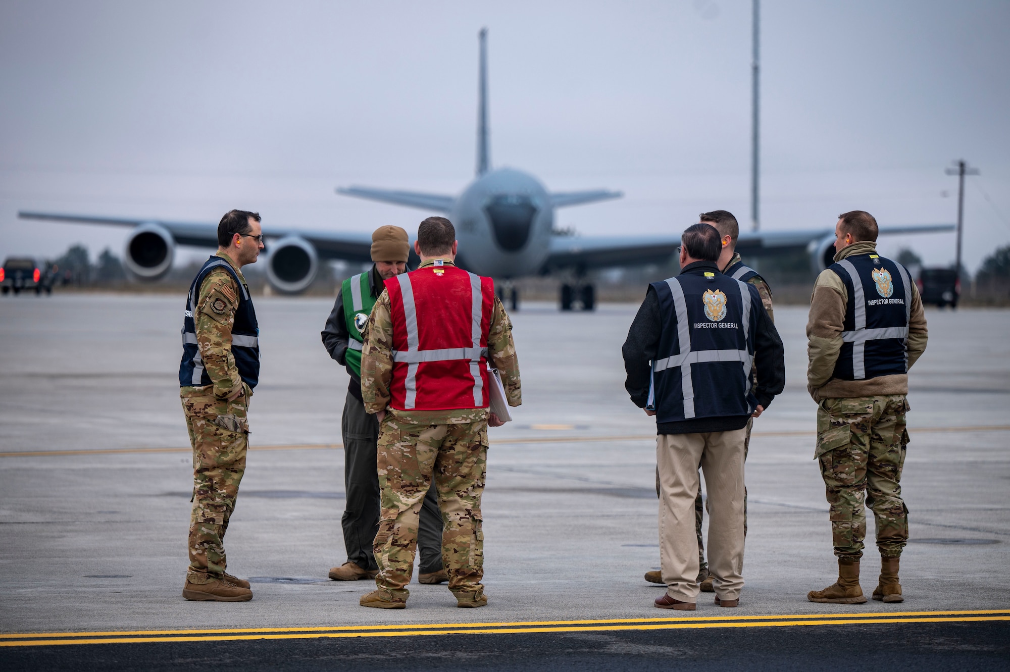 Inspecting officials observe Airmen and aircraft on the flightline.