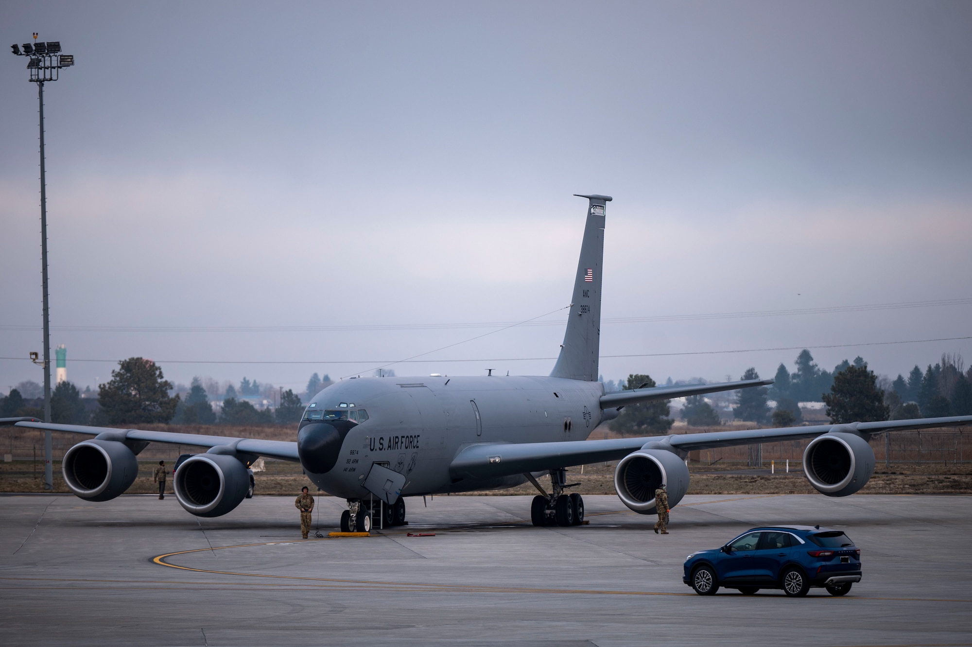 Airmen walk around an aircraft on the flightline.